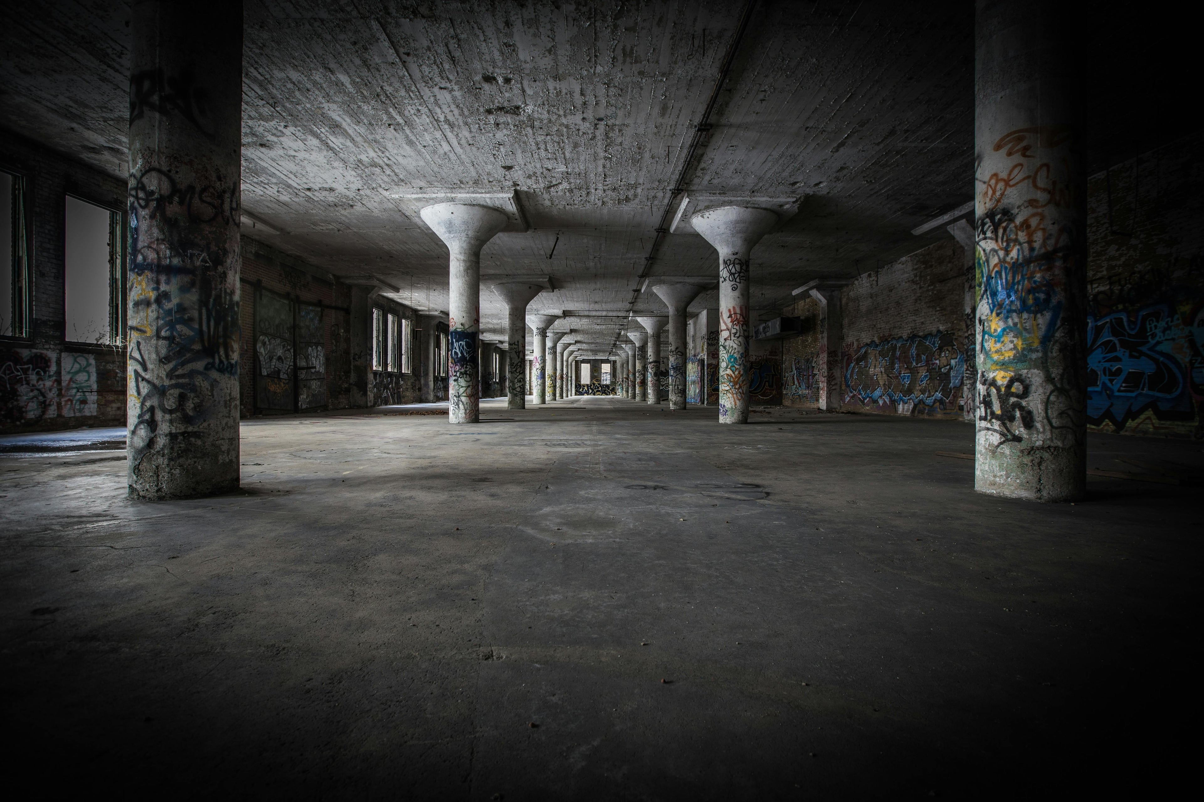 Abandoned industrial interior with graffiti on concrete pillars